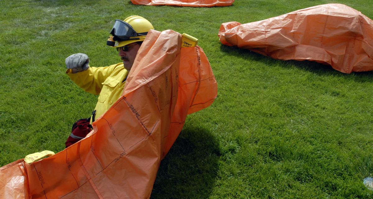 Spokane Valley Fire Department firefighter Eric Swanson practices getting into his fire shelter during the wildland exercise on May 27. (J BART RAYNIAK / The Spokesman-Review)
