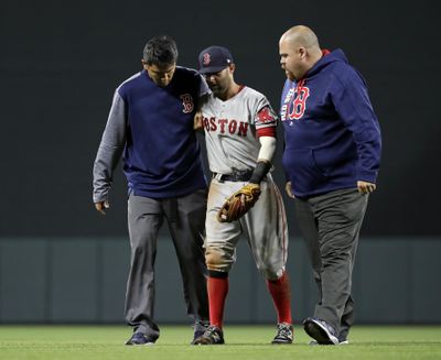 Boston Red Sox second baseman Dustin Pedroia, center, is assisted off the field after being injured during the eighth inning of the team's baseball game against the Baltimore Orioles in Baltimore, Friday, April 21, 2017. (Patrick Semansky / AP)