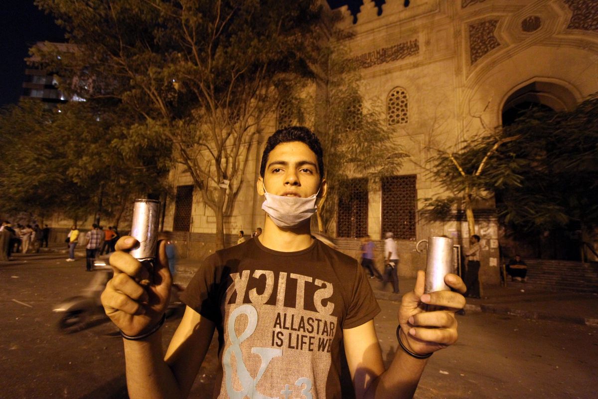 An Egyptian protester holds tear gas canisters fired during clashes between Egyptian police and protesters in front of the U.S. embassy in Cairo, Egypt ,Thursday, Sept. 13, 2012, as part of widespread anger across the Muslim world about a film ridiculing Islam