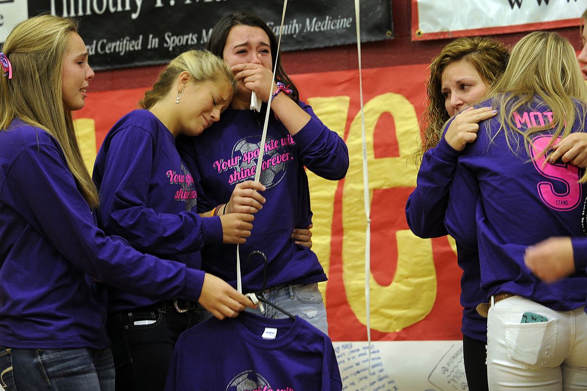 University High School girls soccer coach Megan Poulson, third from right, tries to console members of the team as they retired the No. 9 jersey for McKenzie Mott during an assembly held at the school on Friday for Mott and Josie Freier. (Kathy Plonka)