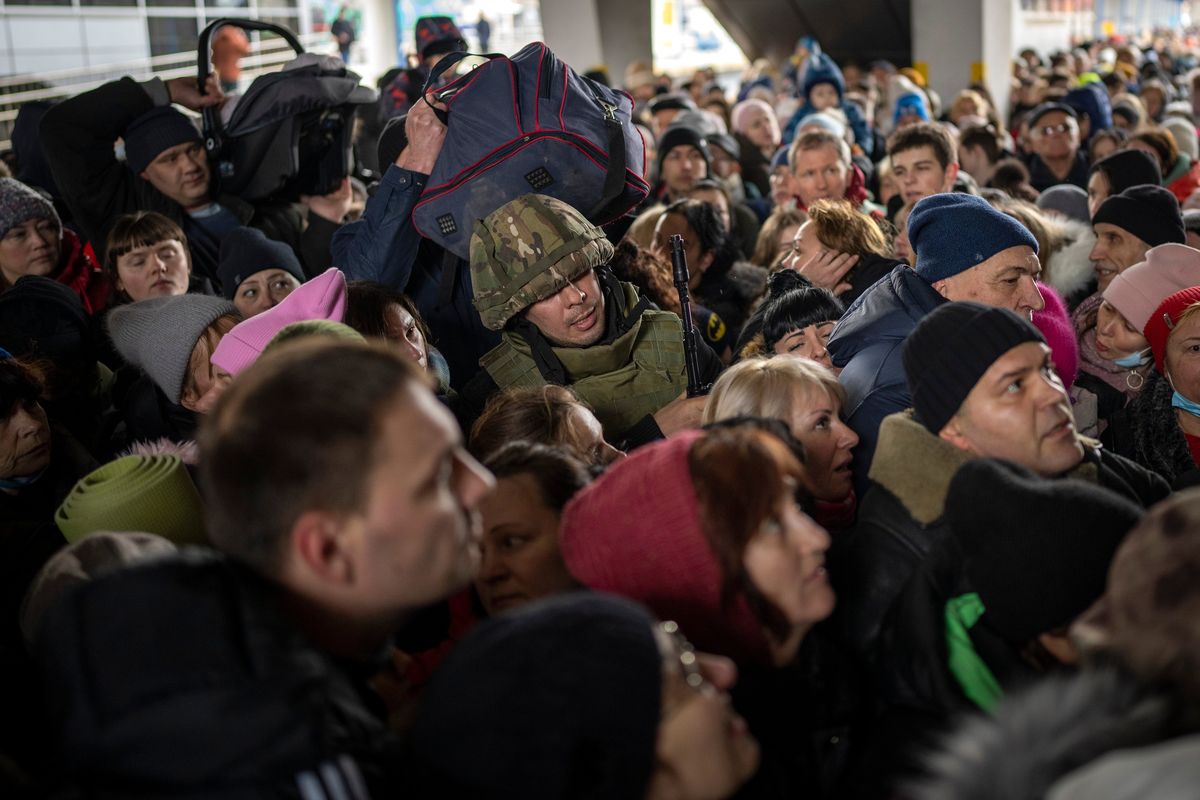 A Ukrainian soldier tries to disperse the crowd as they push to enter a train to Lviv at the Kyiv station, Ukraine, Friday, March 4. 2022. Ukrainian men have to stay to fight in the war while women and children are leaving the country to seek refuge in a neighboring country.  (Emilio Morenatti)