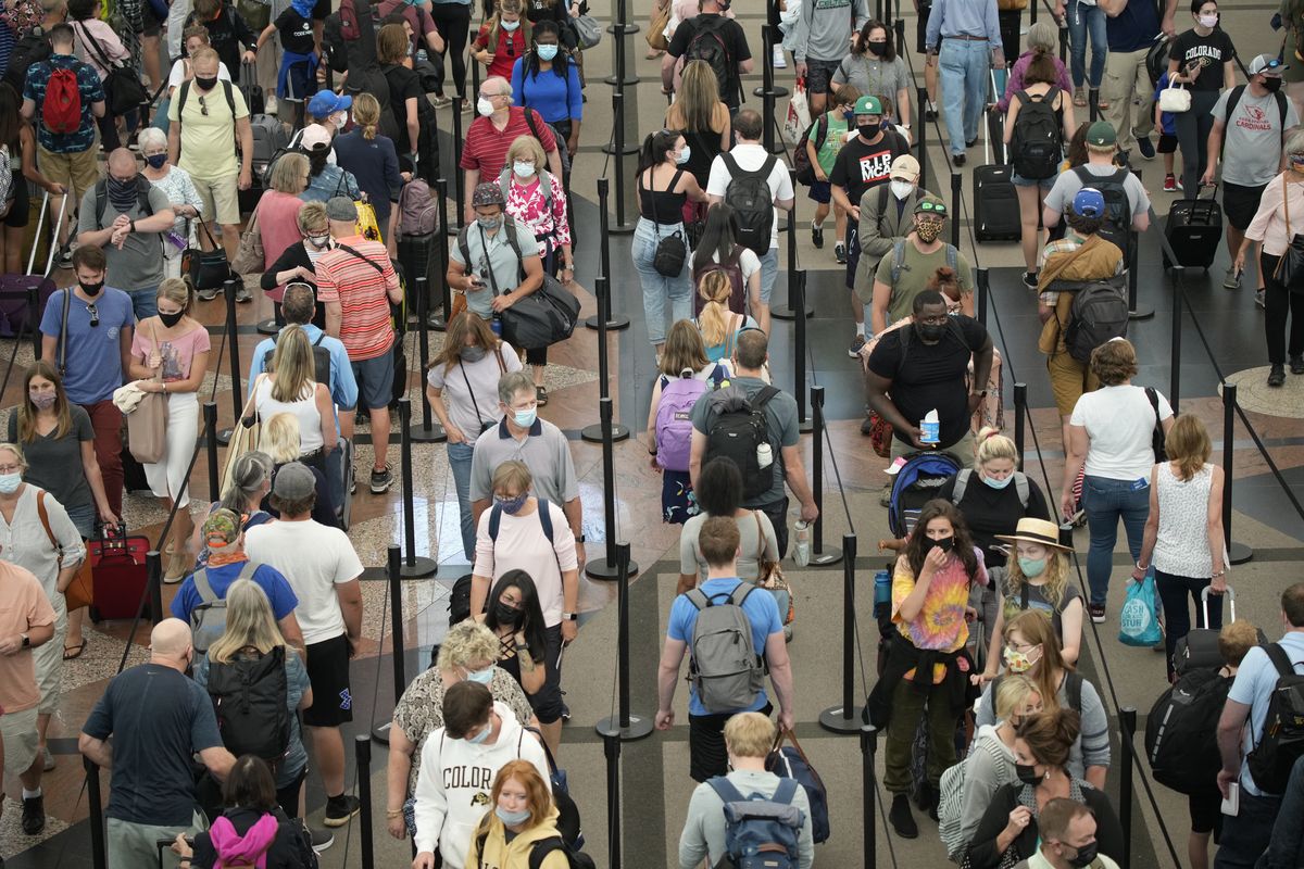 FILE - Travelers queue up in long lines to pass through the south security checkpoint in Denver International Airport, Wednesday morning, June 16, 2021, in Denver. The federal requirement to wear face masks on airplanes and public transportation is scheduled to expire next week, and airline executives and Republican lawmakers are urging the Biden administration to let the mandate die. The fate of the rule — and consideration of an alternate “framework” of moves to limit the spread of COVID-19 — was under discussion Monday, April 11, 2022 within the U.S. Centers for Disease Control.  (David Zalubowski)