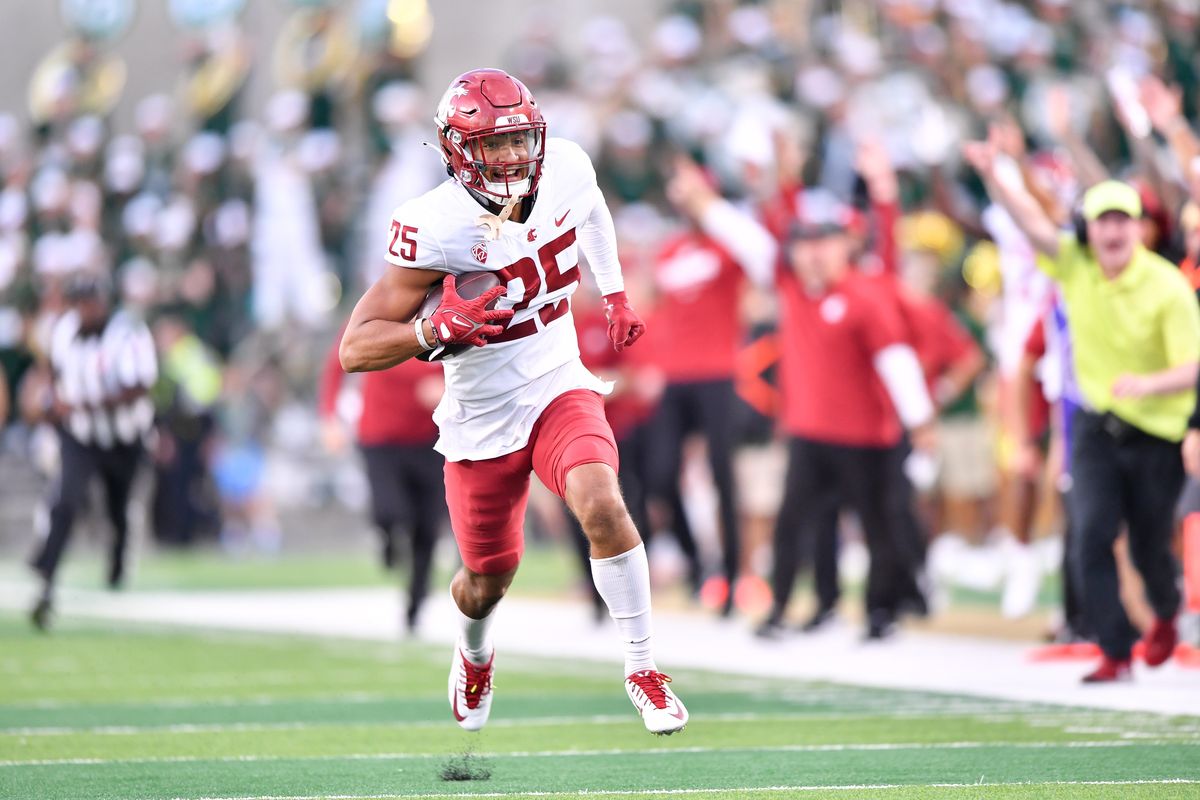 Washington State’s Jaden Hicks smiles as he runs to the end zone with an interception return during Saturday’s win against host Colorado State.  (Tyler Tjomsland/The Spokesman-Review)