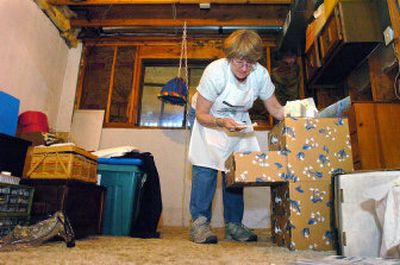 
Jill Jurvelin of Coeur d'Alene sorts through boxes in her home last week as her own first 