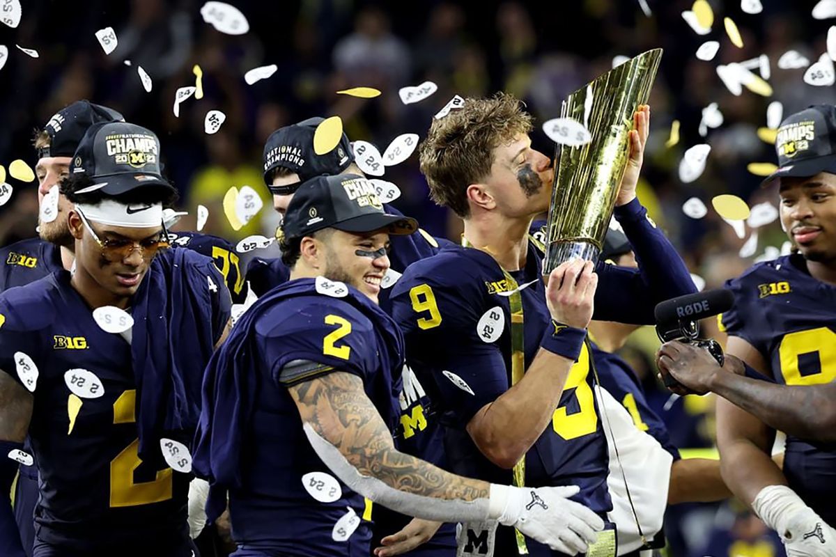Michigan quarterback J.J. McCarthy, right, celebrates his Wolverines winning the College Football Playoff championship game at NRG Stadium in Houston on Jan. 8. Michigan won its first national title since 1997, topping Washington 34-13.  (Tribune News Service)