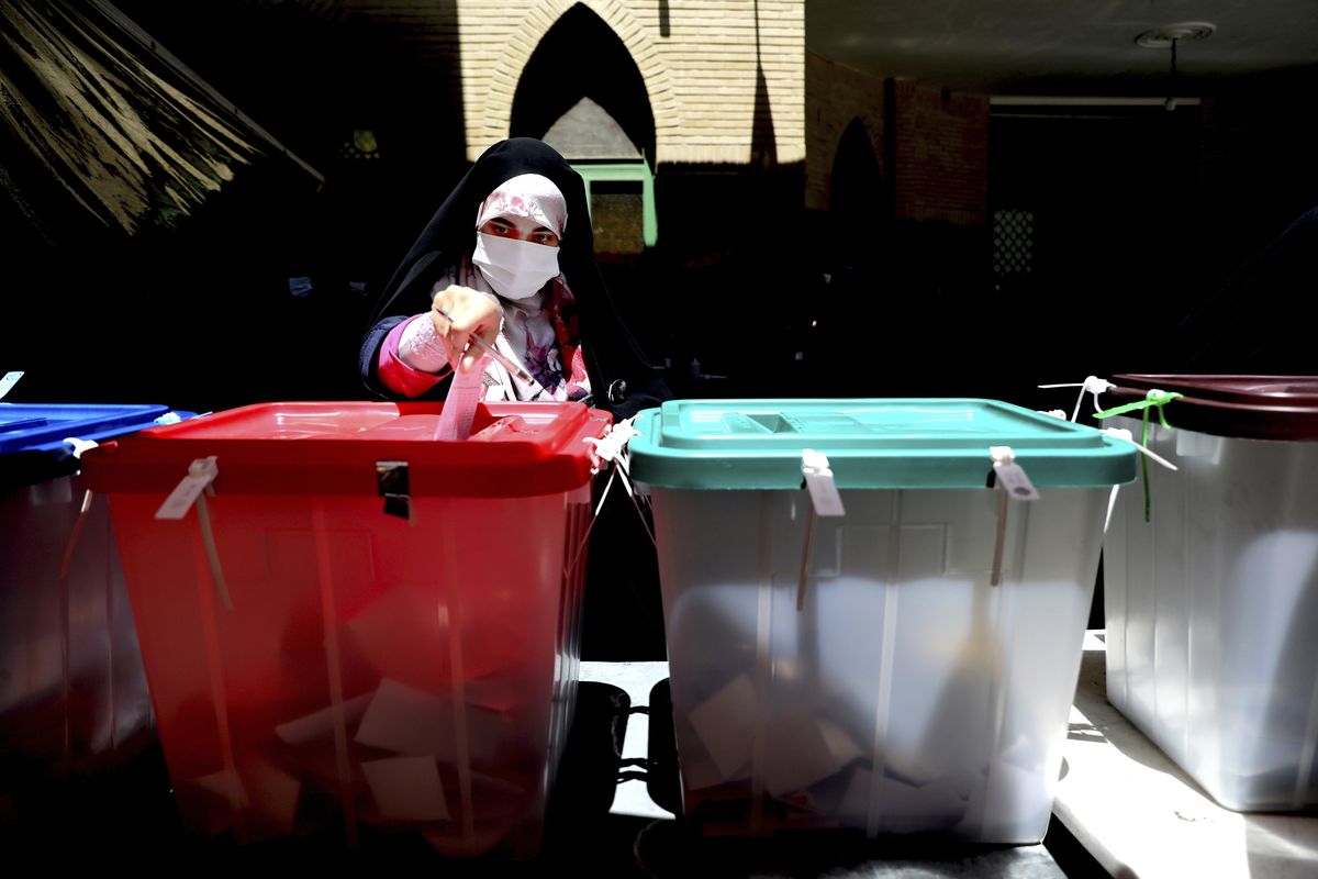 A voter casts her ballot for the presidential election at a polling station in Tehran, Iran, Friday, June 18, 2021. Iranians voted Friday in a presidential election that a hard-line protege of Supreme Leader Ayatollah Ali Khamenei seemed likely to win, leading to low turnout fueled by apathy and calls for a boycott.  (Ebrahim Noroozi)