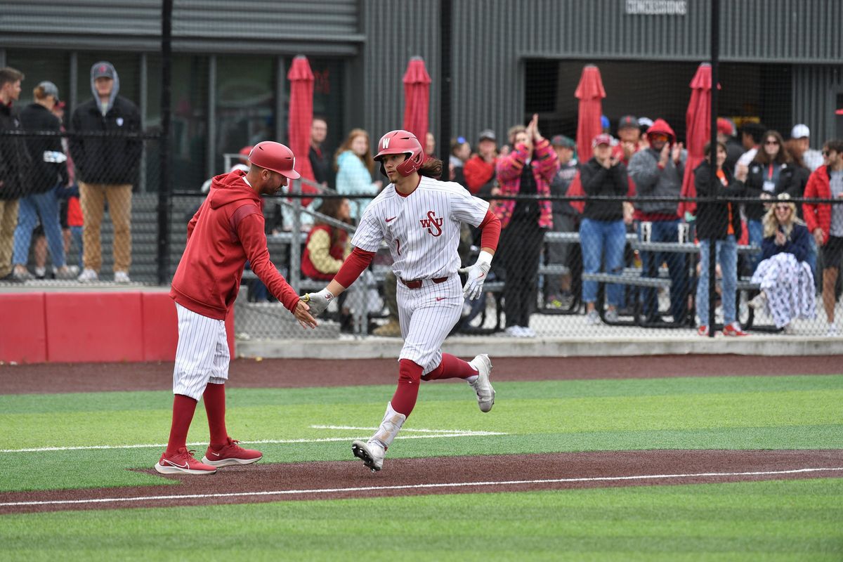 Washington State infielder Kyle Russell high-fives a coach against Arizona State on Saturday in Pullman.  (WSU Athletics)