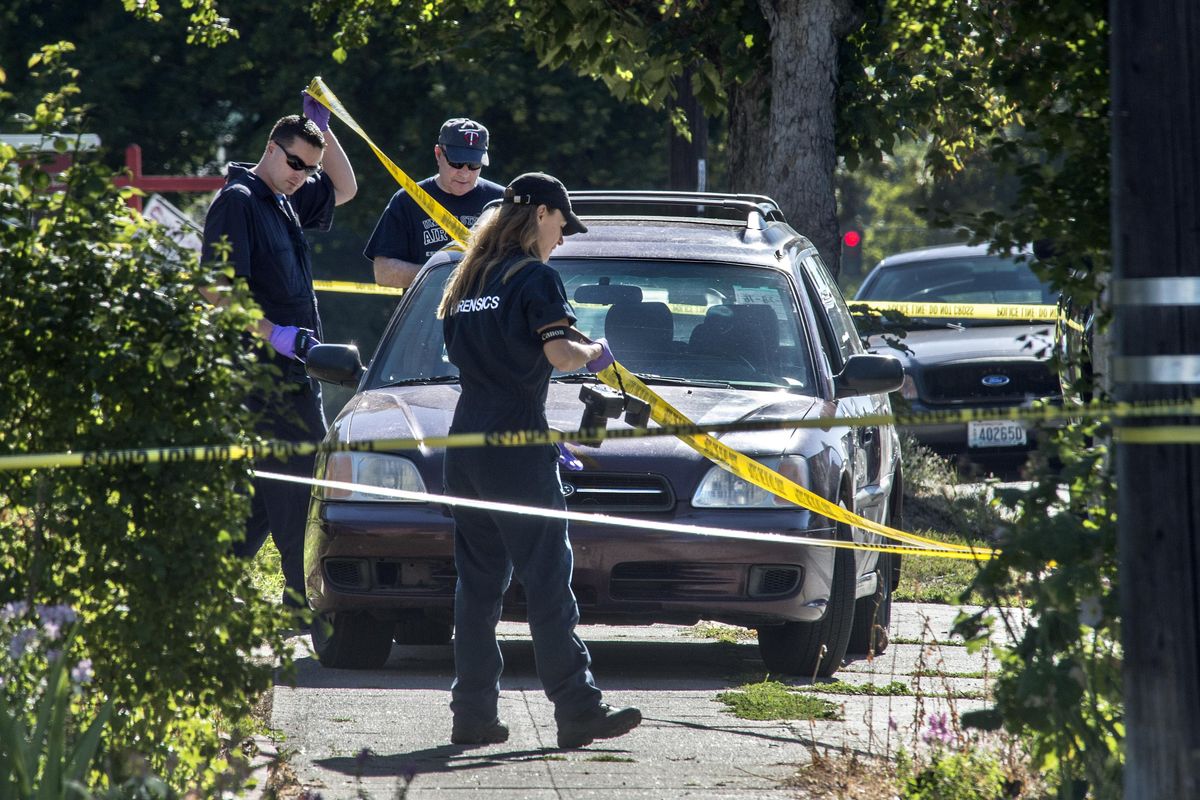 Members of the Spokane Police Department forensics team and major crimes detectives pay close attention to a Subaru Legacy at the scene of a homicide on Saturday, July 30, 2016, in the 1300 block of West Maxwell Avenue in Spokane. (Dan Pelle / The Spokesman-Review)