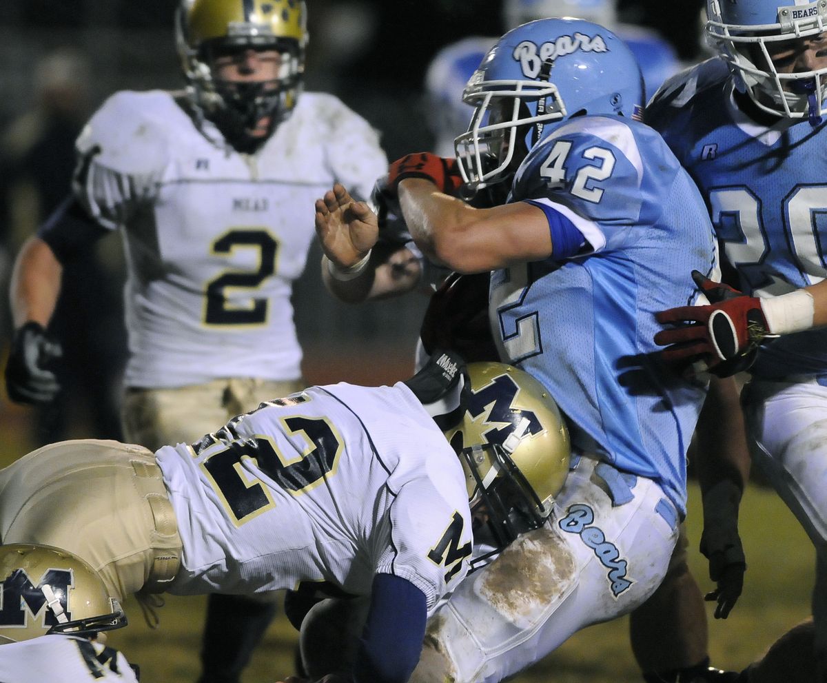 The Spokesman-Review Mead’s Kyle Courtney wraps up Central Valley running back Taylor Price in the first quarter. (Dan Pelle / The Spokesman-Review)