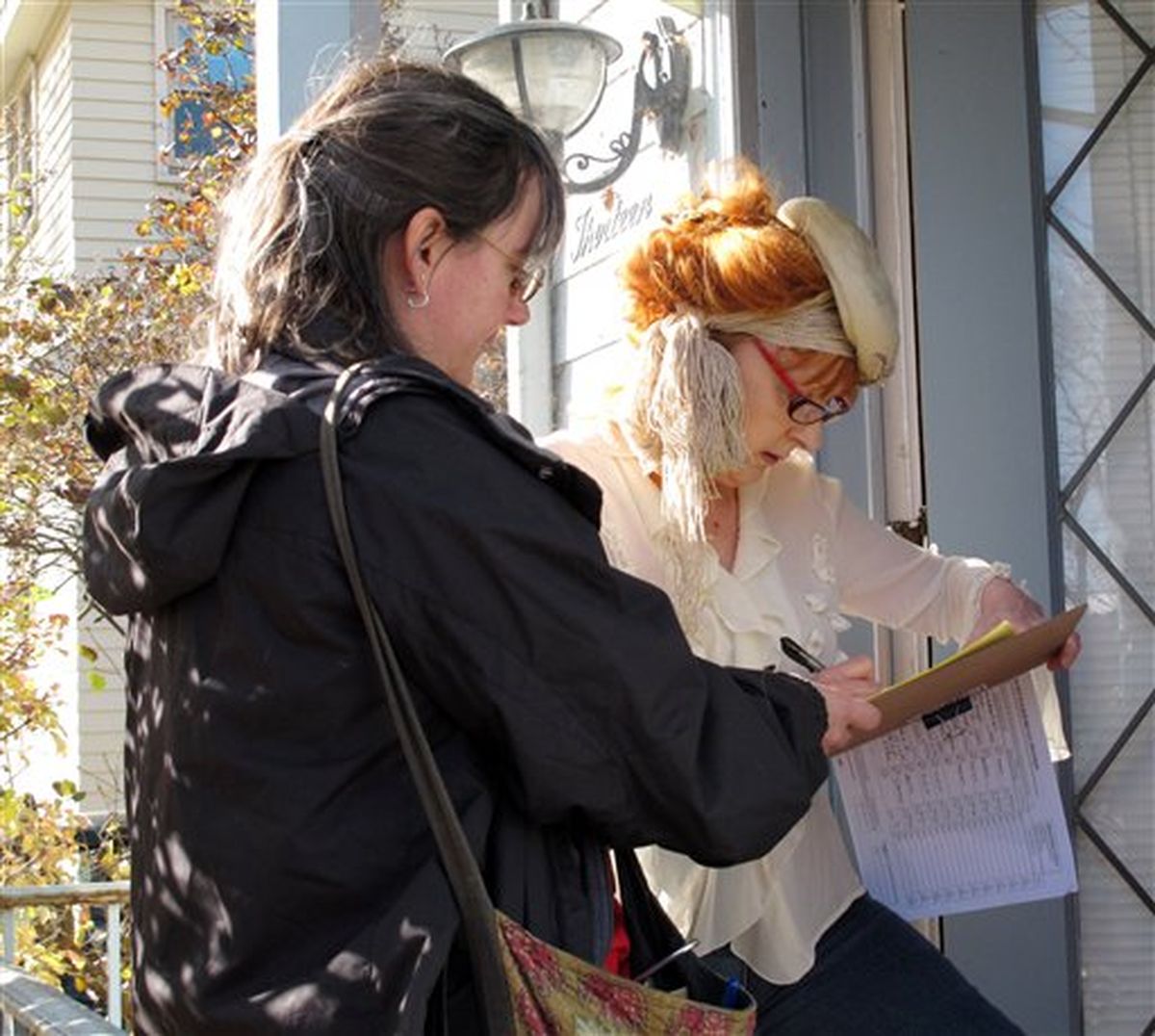 Carla Koykkari, right, of Madison, Wis., signs a petition Tuesday to force a recall election against Wisconsin Gov. Scott Walker as petition circulator Sue Breckenridge observes. (Scott Bauer / Associated Press)