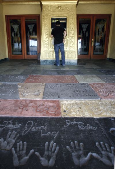 A man checks movie times at the Vista movie theater in Los Angeles on Friday. Industry experts say box office receipts skew the picture of which movies have been most popular.  (Associated Press / The Spokesman-Review)