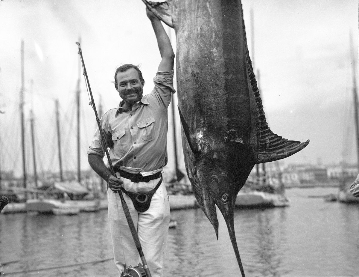 In this July 1934 photo provided by the John F. Kennedy Library Foundation from the Ernest Hemingway Collection, Ernest Hemingway poses with a marlin at Havana Harbor, in Key West, Fla. A new three-part documentary about Hemingway, which relied heavily on the archives at the John F. Kennedy Presidential Library and Museum in Boston, debuts April 5, 2021, on PBS.  (HONS)
