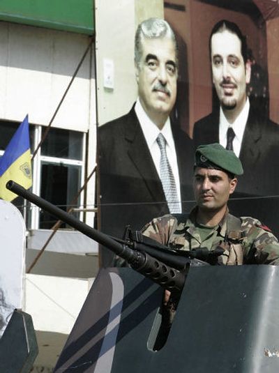 
A Lebanese soldier stands in front of a poster of slain former Prime Minister Rafik Hariri in Beirut on Thursday, when Lebanese authorities took additional security measures as the country awaited a report on Hariri's assassination. 
 (Associated Press / The Spokesman-Review)