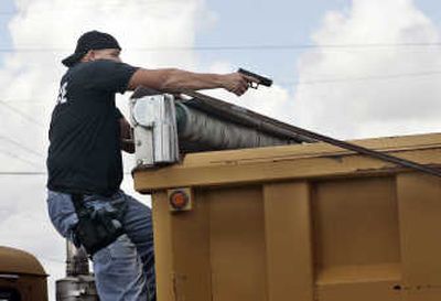 
A Miami-Dade police officer checks an 18-wheel truck Thursday during a manhunt in Cutler Bay, Fla. Associated Press
 (Associated Press / The Spokesman-Review)