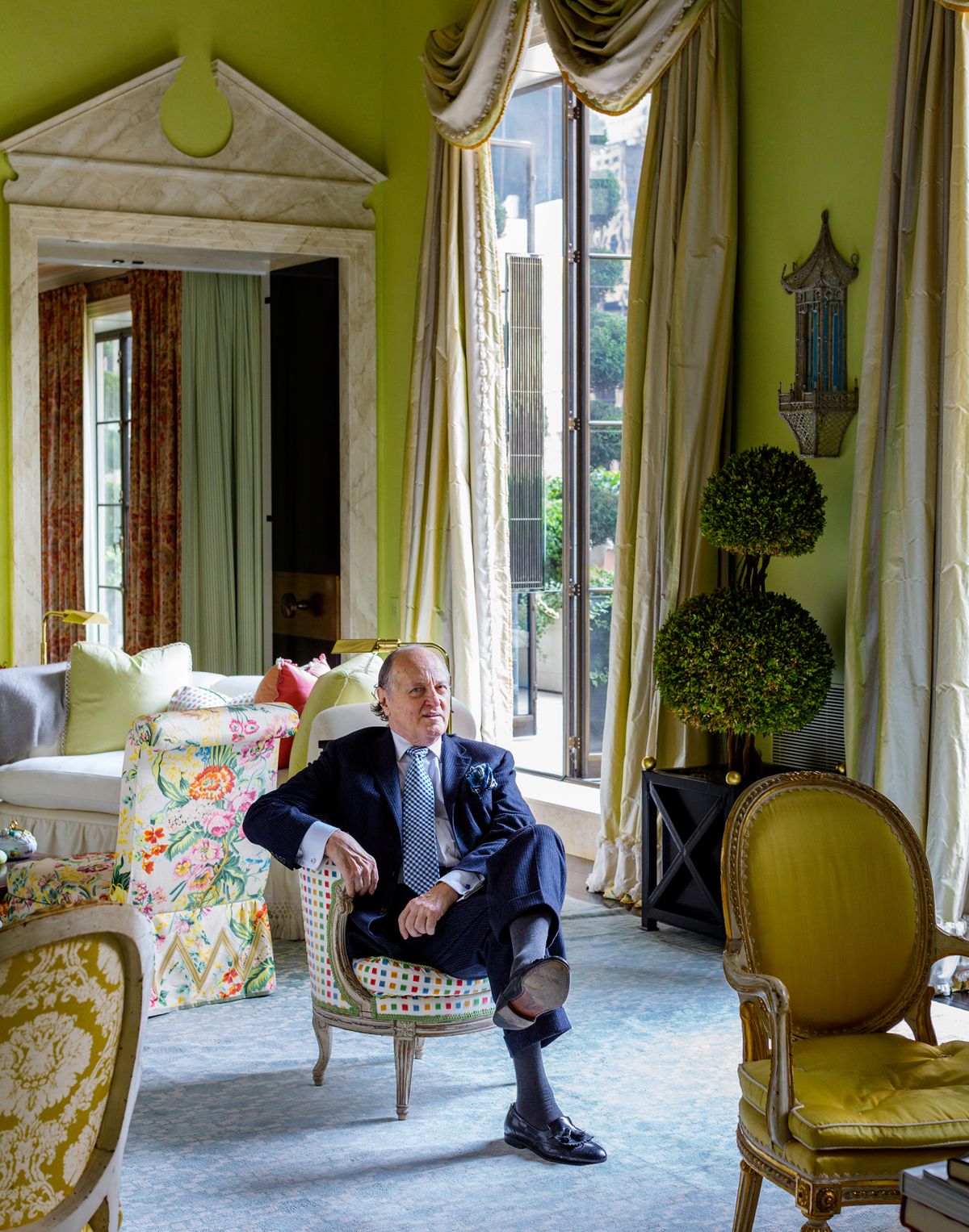 FILE – The Late designer Mario Buatta, who was considered “the Prince of Chintz,” in a space he designed for Hilary and Wilbur Ross, the former secretary of commerce, on West 57th Street in Manhattan in 2014. Ruffles and their close cousin chintz – the often bright floral fabric with a glossy finish – are returning, partly in rebellion to the minimalist aesthetic that has dominated interior design for so long.  (Trevor Tondro/The New York Times))