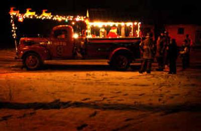 
Members of the Mead Fire Department and Santa cruise the streets of Mead for seven nights in an old, donated Kaiser Aluminum firetruck handing out candy canes and Christmas cheer. 
 (Jed Conklin / The Spokesman-Review)