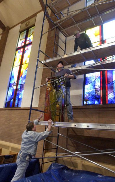 
At the Millwood Community Presbyterian Church on Thursday, Scott Graham, bottom, a stained-glass artist for Reflections Stained Glass, lifts a panel to Allen Fenter, a commercial glazier for Valley Glass, who in turn will lift it to Chris O'Neel for installation.  
 (J. BART RAYNIAK / The Spokesman-Review)