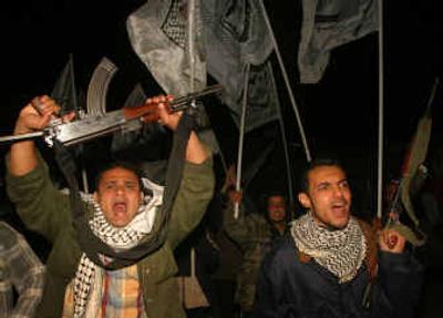 
Palestinian militants from the Fatah movement demonstrate to show their support for an attack at a nearby Israeli checkpoint on the Gaza-Egypt border on Sunday. 
 (Associated Press / The Spokesman-Review)