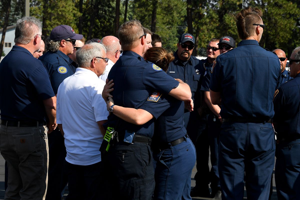 Firefighters embrace following a news conference Monday at the Spokane County Fire District 9 in Mead after Lt. Cody Traber was killed in the line of duty on Thursday while answering a fire call in north Spokane near Highway 395 and Wandermere Road.  (Tyler Tjomsland/The Spokesman-Review)