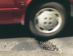 In this SR file photo by Dan Pelle, a car takes a pounding as it hits a Spokane pothole.
