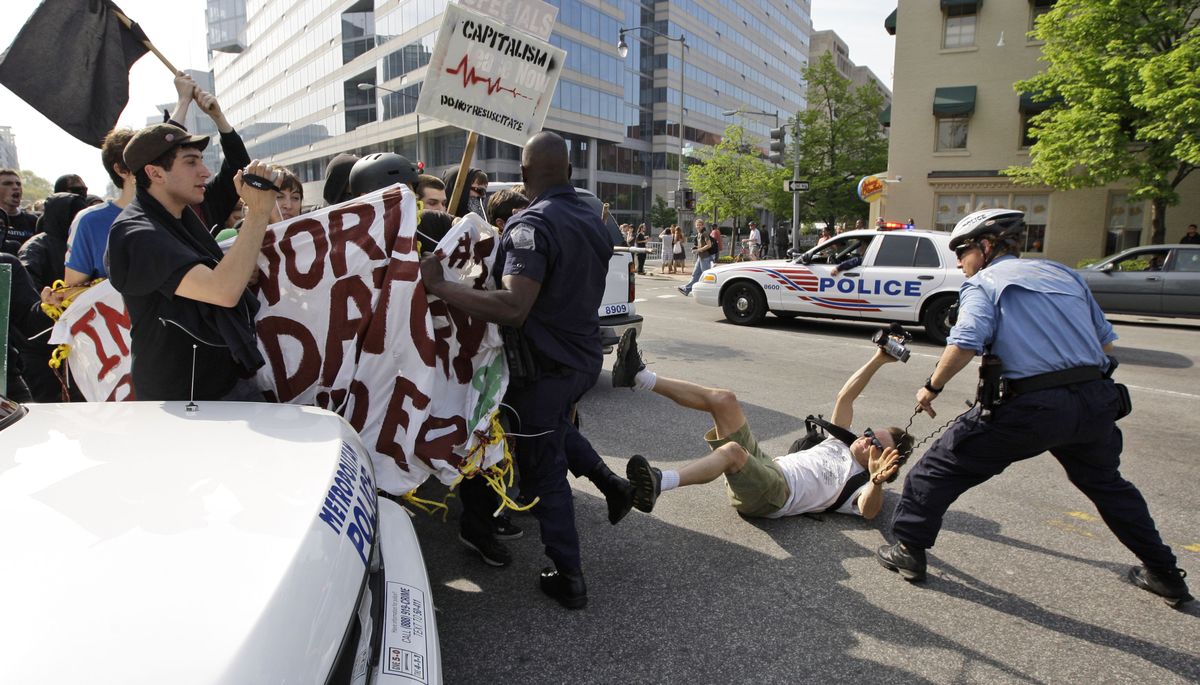Protesters clash with law enforcement officers during a demonstration against the International Monetary Fund in Washington, D.C., on Saturday. (Alex Brandon / The Spokesman-Review)