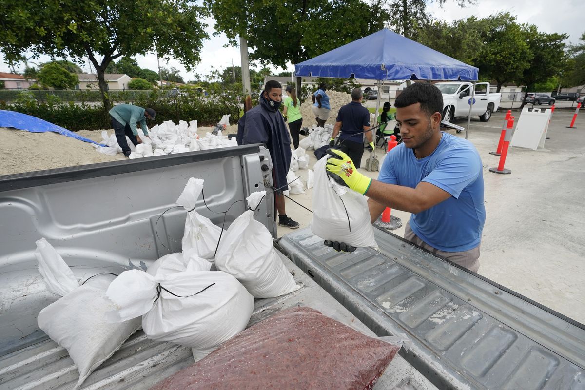 City workers load sandbags at a drive-thru sandbag distribution event for residents ahead of the arrival of rains associated with tropical depression Fred, Friday, Aug. 13, 2021, at Grapeland Park in Miami. Forecasters say tropical depression Fred is slowly strengthening and could regain tropical storm status Friday. (Wilfredo Lee)