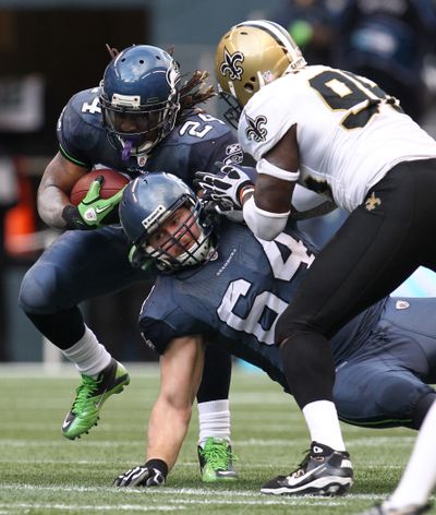 Seattle Seahawks' Marshawn Lynch (24) carries the ball under pressure from New Orleans Saints' Alex Brown as Seahawks Mike Gibson (64)  falls during the play in the first half of an NFL NFC wild card playoff football game, Saturday, Jan. 8, 2011, in Seattle. (John Froschauer / Fr74207 Ap)