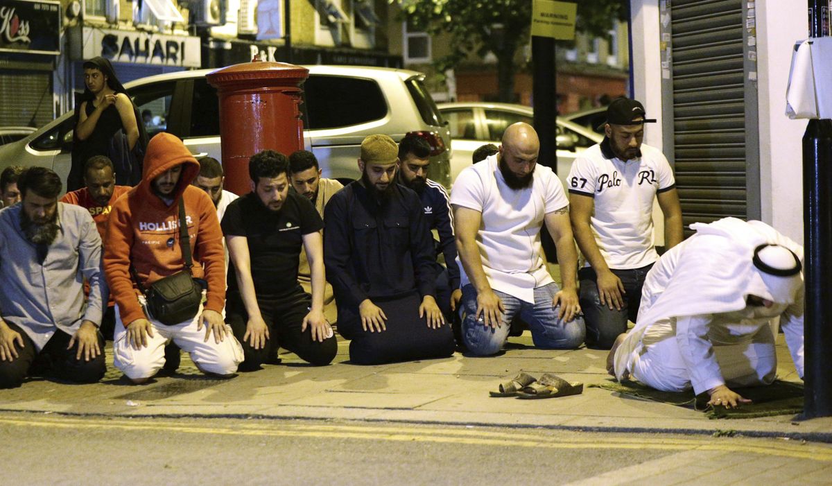 Local people observe prayers at Finsbury Park where a vehicle struck pedestrians in London Monday, June 19, 2017. Police say a vehicle struck pedestrians near a mosque in north London, leaving several casualties and one person was arrested. (Yui Mok / Yui Mok/PA via AP)
