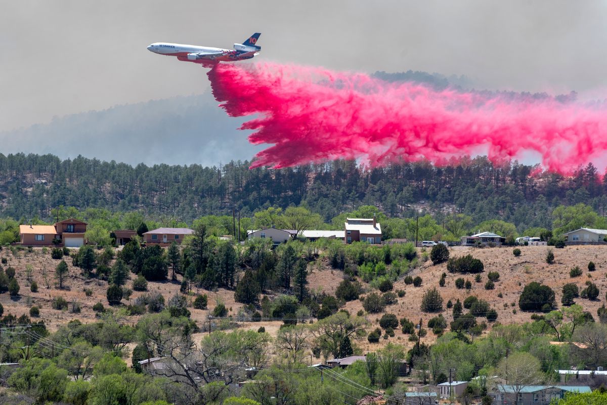 A slurry bomber dumps the fire retardant between the Calf Canyon/Hermit Peak Fire and homes on the westside of Las Vegas, N.M., Tuesday, May 3, 2022. Several types of aircraft joined the fight to keep the fire away for the Northern New Mexico town. (Eddie Moore)