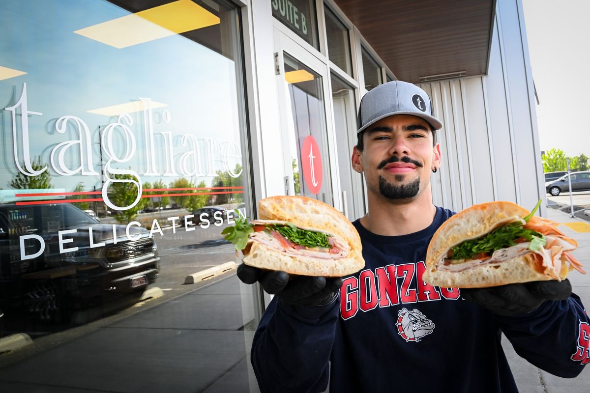 Owner Van Vega holds up the Hall and Oats sandwich in front of Tagliare Delicatessen on May 12 in Airway Heights.  (Tyler Tjomsland/The Spokesman-Review)