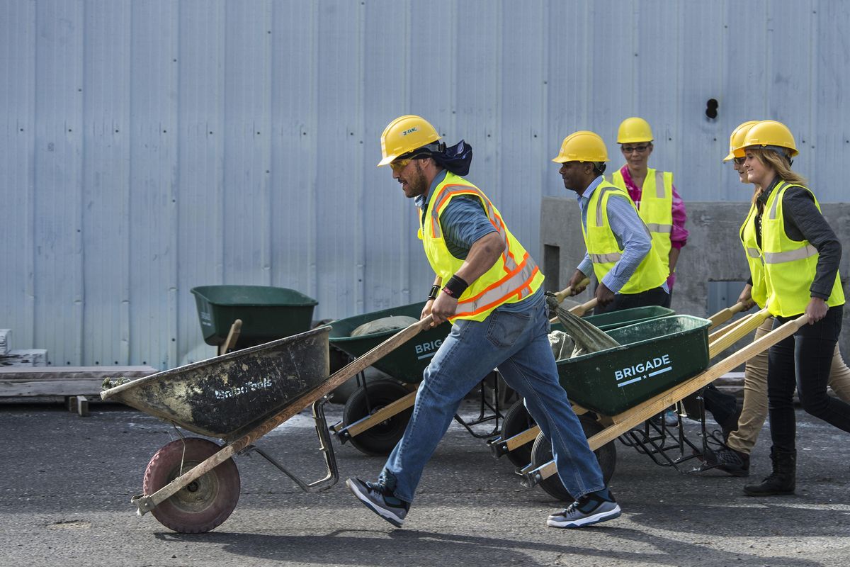 Jason Jennings, left, breaks out to take the lead in  a wheelbarrow race at the Spokane Community College Apprenticeship Training Center. The students pushed a load weighing 40 pounds and were instructed not to run. (Dan Pelle / The Spokesman-Review)