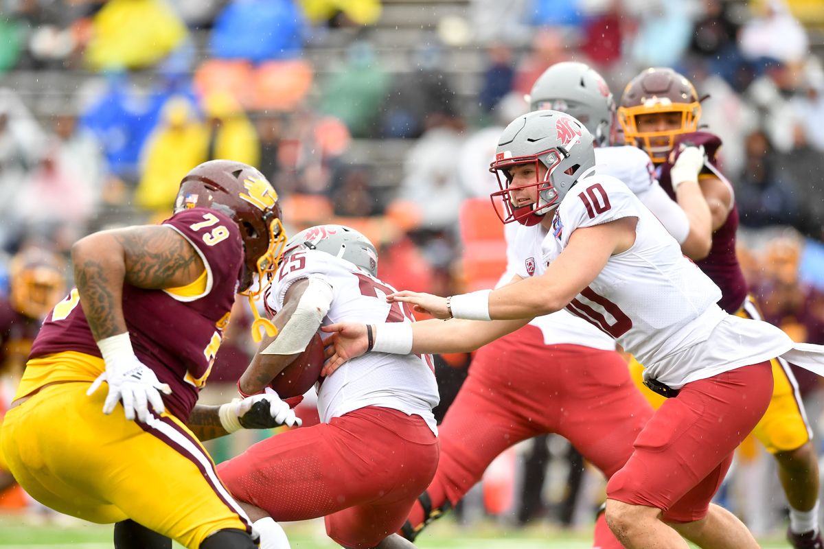 Washington State Cougars quarterback Victor Gabalis (10) hands the ball off to running back Nakia Watson (25) during the second half of a college football game on Friday, Dec. 31, 2021, at the Sun Bowl in El Paso, Texas. The Central Michigan Chippewas won the game 24-21.  (Tyler Tjomsland/The Spokesman-Review)