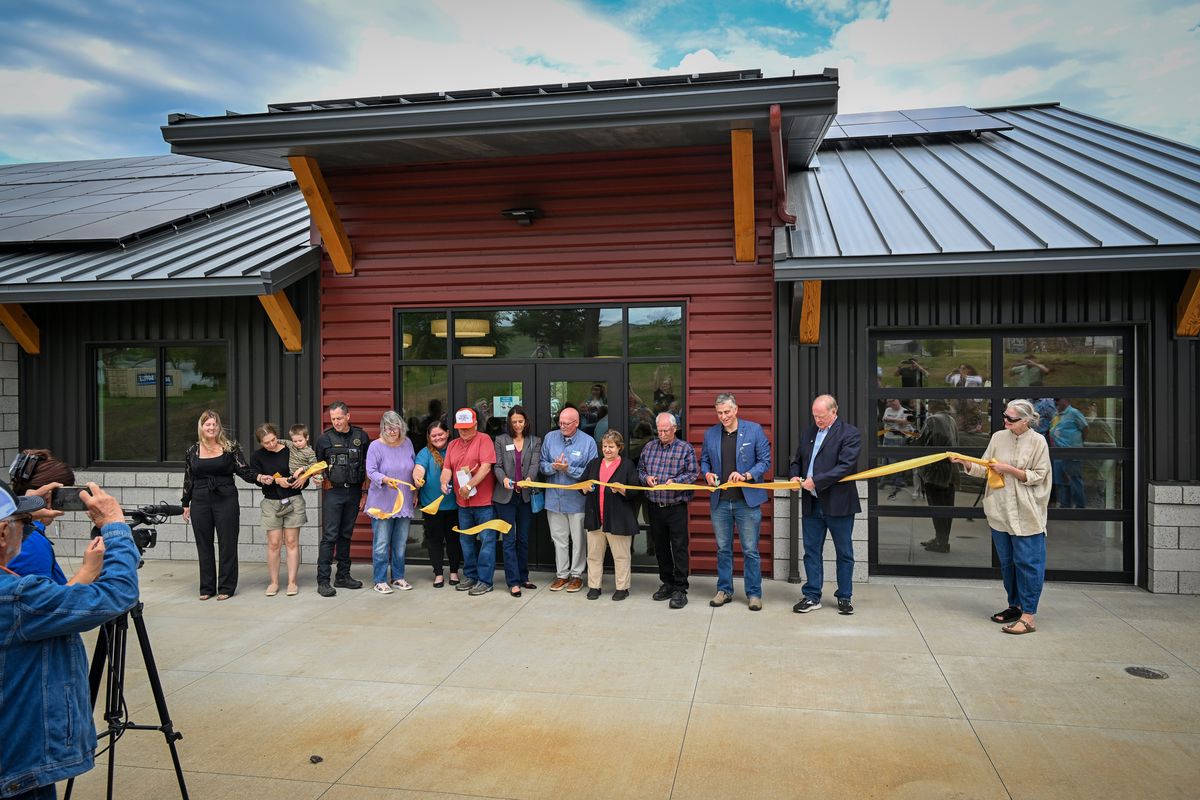 Officials from the city, Whitman County and the state of Washington and representatives of many benefactors and donors join in to cut the ribbon outside the new community building Thursday in Malden, Wash. The building also houses the library, the food bank and a community meeting room and kitchen. Malden, located in Whitman County, was destroyed by a fire on Labor Day in 2020. (Jesse Tinsley/THE SPOKESMAN-REVIEW)