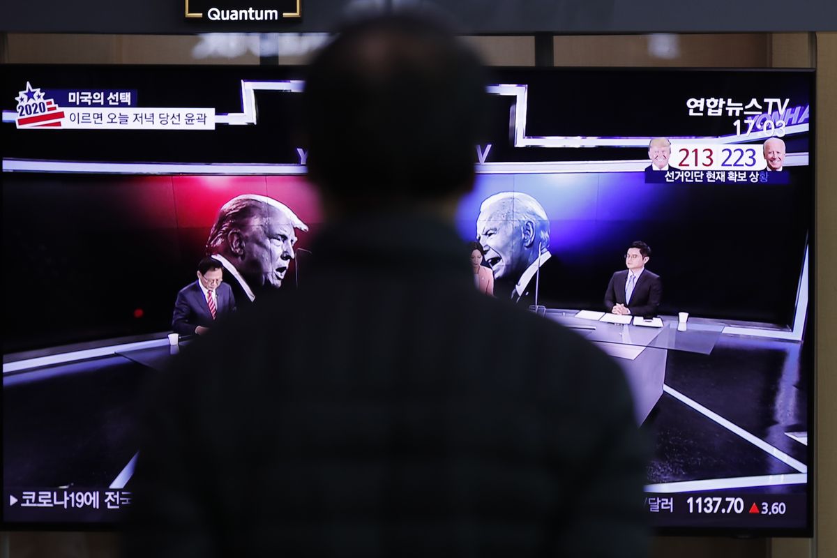 A man watches a TV screen showing the images of U.S. President Donald Trump and Democratic presidential candidate former Vice President Joe Biden during a news program of the U.S. presidential election, at the Seoul Railway Station in Seoul, South Korea, Wednesday, Nov. 4, 2020.  (Lee Jin-man)