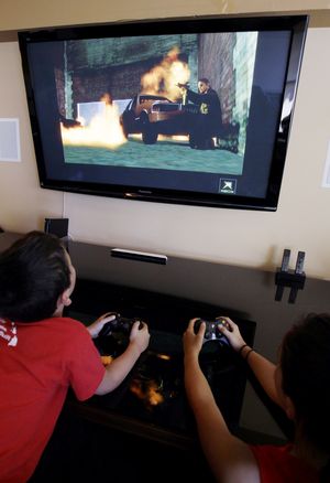 JT Taga-Anderson, 9, left, and Mika Taga-Anderson, 13, play Grand Theft Auto IV in Los Altos, Calif. The Supreme Court today ruled that California cannot ban the rental or sale of violent video games to children. (AP/Paul Sakuma)