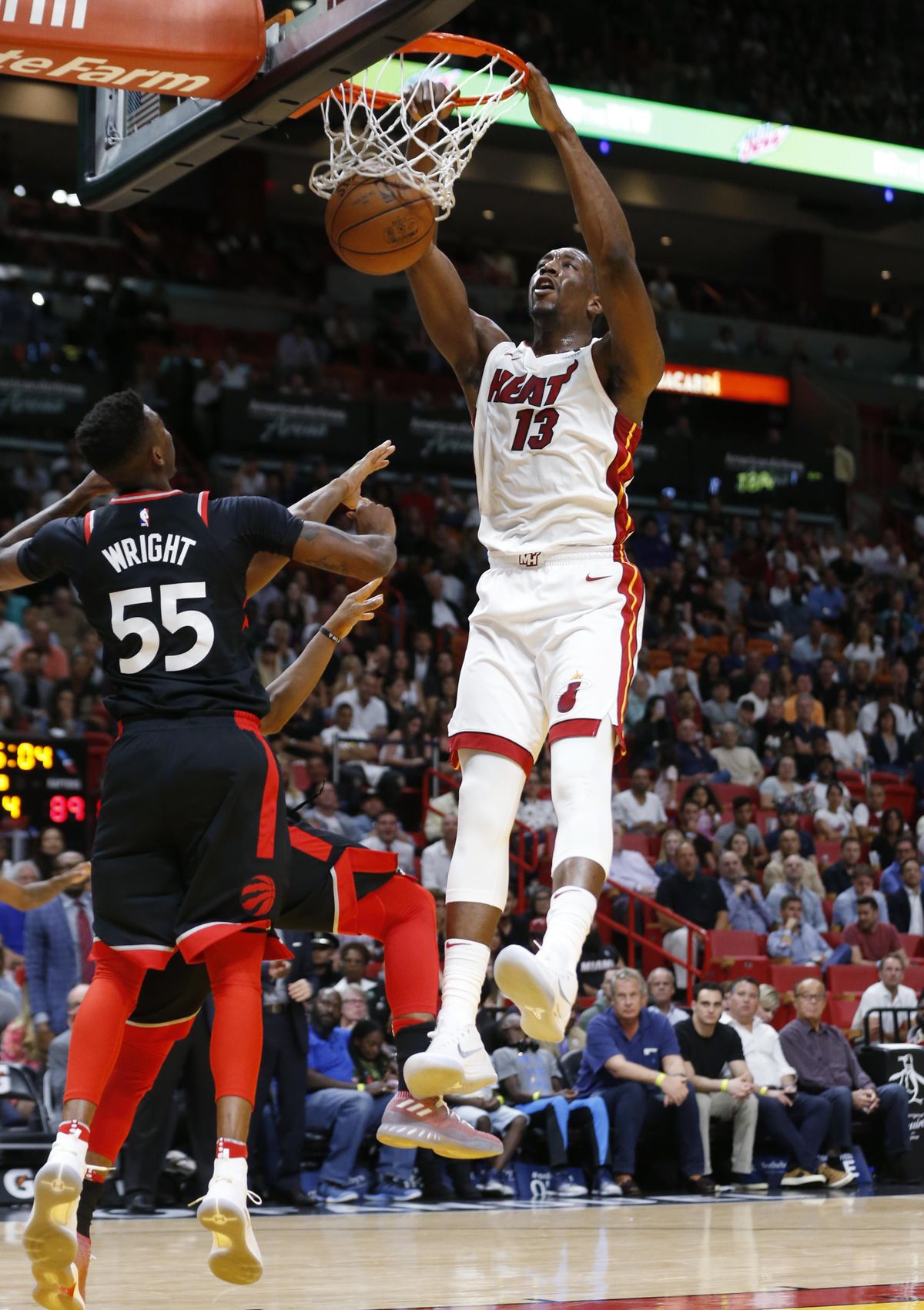 Miami Heat center Bam Adebayo (13) dunks in front of Toronto Raptors guard Delon Wright (55) and guard Kyle Lowry, left rear, during the second half of an NBA basketball game Wednesday, April 11, 2018, in Miami. The Heat won 116-109 in overtime. (Wilfredo Lee / Associated Press)