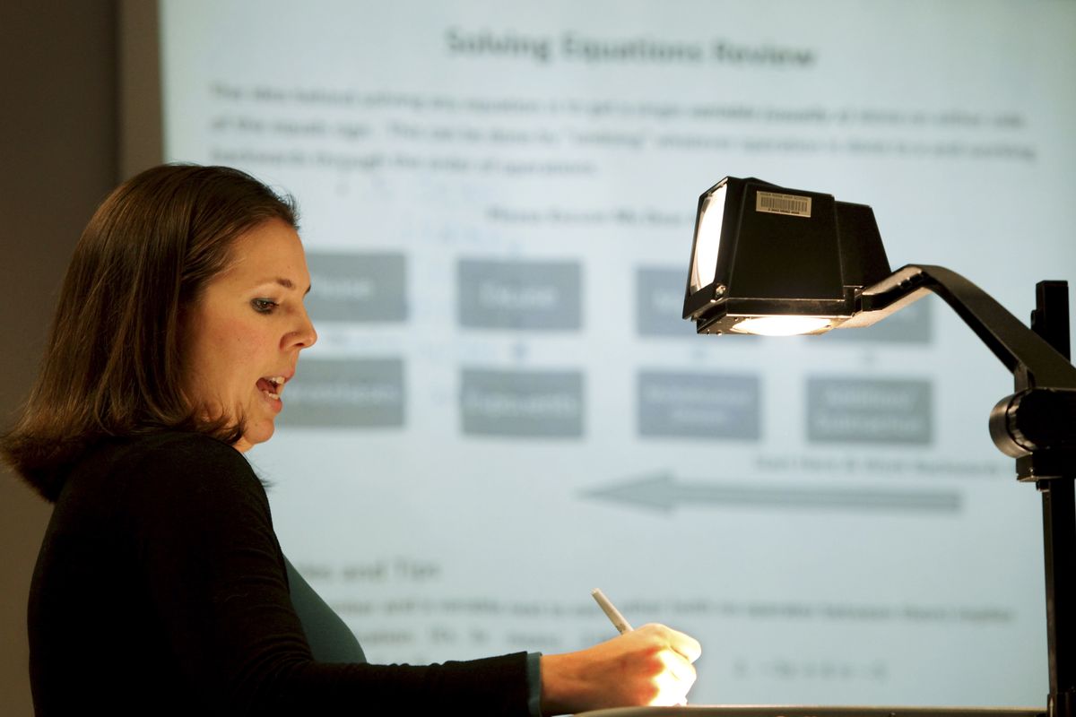 River Ridge High teacher Jami Gore instructs a math problem during her monthly Algebra Class for Parents in Olympia. She created the class to give parents a refresher in the subject so they can help their children. (Associated Press)