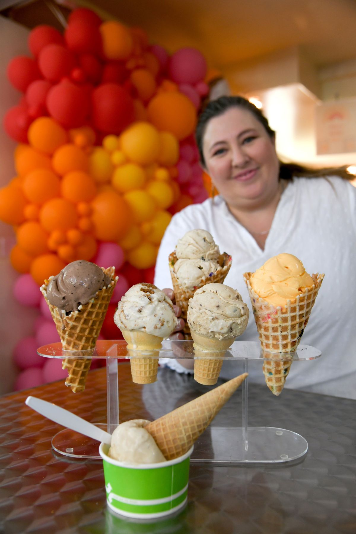 Owner Jennifer Davis shows off the top five ice cream flavors at The Scoop. She has two locations in Spokane, 1001 W. 25th Ave. and 1238 W. Summit Parkway in Kendall Yards. The flavors shown are, in the cup, Salted Caramel; Mud Pie, in the cones from left, Giant’s Milk and Cookies, Banoffee Pie, and Orange Dreamsicle; and Cookie Butter and Cookie Dough, held by Davis.  (Jesse Tinsley/The Spokesman-Review)