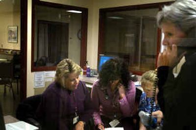 
Michelle Berthon, program administrator for the Behavioral Health Triage, talks on the phone as, from left, Sue Coley, Sharon Boland, both registered nurses, and Sahnnon Czako, a mental health tech, study withdraw protocol papers at the triage center on Thursday. 
 (Jed Conklin / The Spokesman-Review)