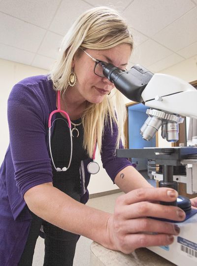 Heather Schaper, a physician assistant and mid-level medical director at Health West in Pocatello, uses lab equipment that can determine whether a person has contracted a sexually transmitted disease. (Doug Lindley / Idaho State Journal)