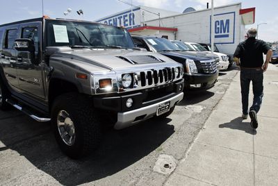 A customer walks past a Hummer and Cadillacs for sale Tuesday at a General Motors dealership in Burlingame, Calif. GM has an agreement to sell its Hummer brand to Sichuan Tengzhong Heavy Industrial Machinery Co. of China.  (Associated Press / The Spokesman-Review)