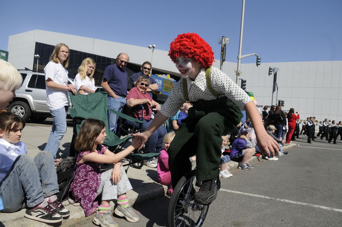 A clown from Salk Middle School pedals  on Bernard Street slapping hands during the  parade, whose   theme was “Circus on Parade.” (Jesse Tinsley / The Spokesman-Review)