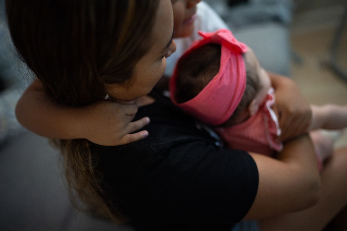 Paola, 29, originally from Honduras, was told earlier this month to wear an ankle bracelet instead of checking in on the mobile app. She is pictured with her 6-year-old son and five-month-old daughter at her Manassas, Va., home. (Sarah L. Voisin)