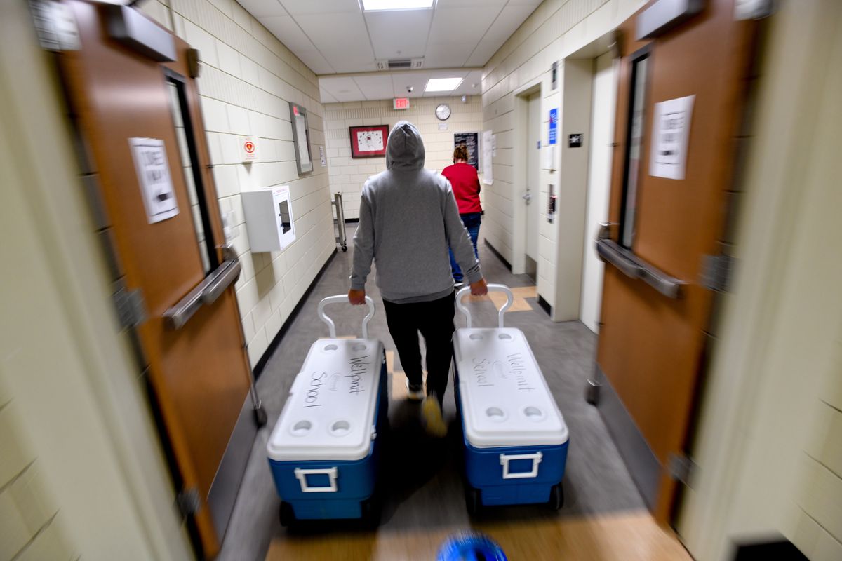 Bert Brisbois, a community liaison with the Wellpinit School District, wheels coolers full of lunches to a van to be delivered to students on Thursday, December 3, 2020, in Wellpinit, Wash.  (Tyler Tjomsland/The Spokesman-Review)