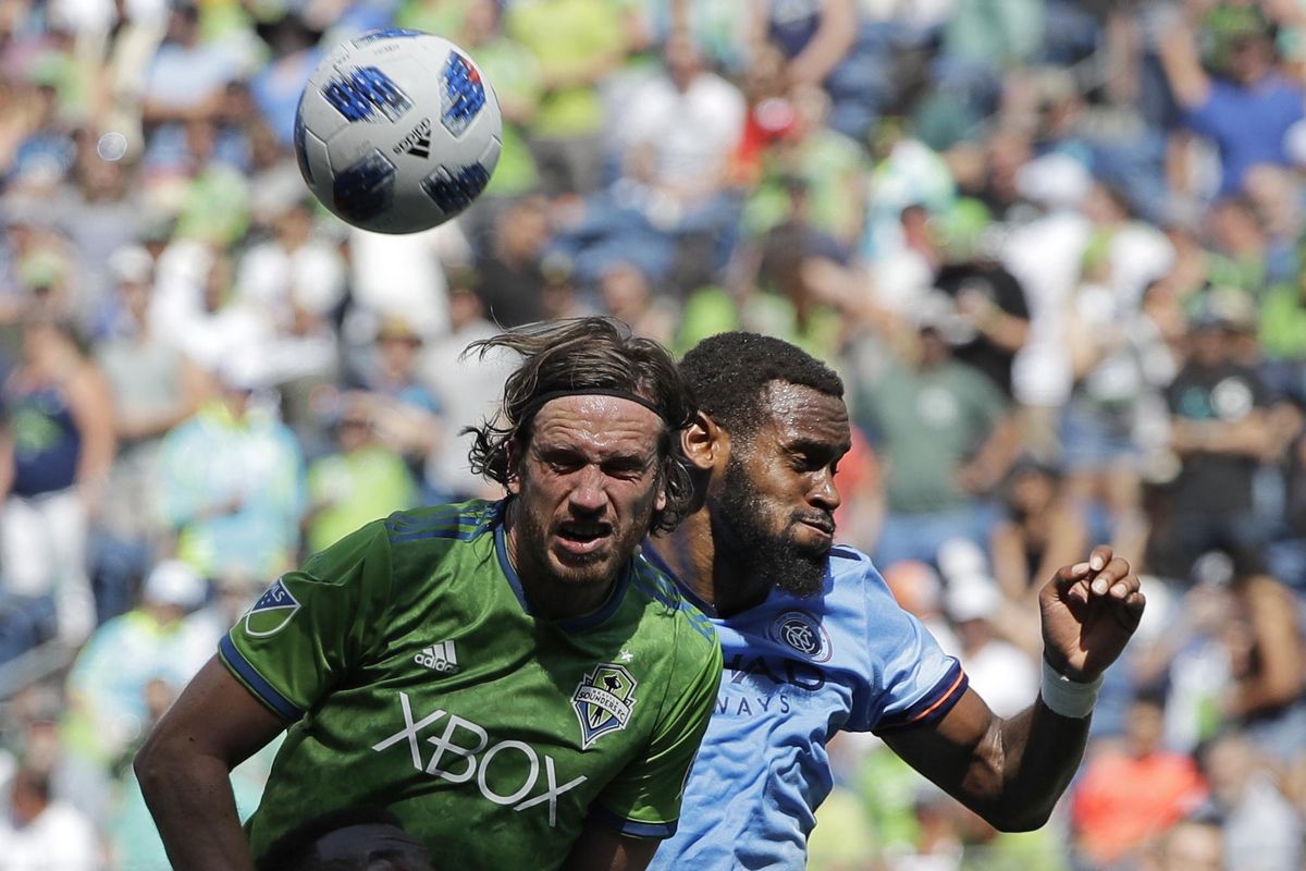 Seattle Sounders midfielder Gustav Svensson, left, battles with New York City FC defender Sebastien Ibeagha, right, for a header during the second half of an MLS match, Sunday, July 29, 2018, in Seattle. (Ted S. Warren / Associated Press)