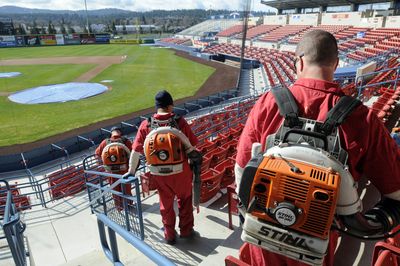 Inmate workers use leaf blowers to clean the stands at Avista Stadium Monday. Some inmates from  Geiger Corrections Center perform labor in and around Spokane during their sentences.  (Jesse Tinsley / The Spokesman-Review)