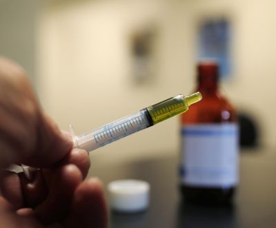 FILE - In this Nov. 6, 2017, file photo, a syringe loaded with a dose of CBD oil is shown in a research laboratory at Colorado State University in Fort Collins. In a report released Thursday, May 24, 2018, the Centers for Disease Control and Prevention found that synthetic products falsely labeled as cannabidiol, or CBD, sickened as many as 52 people from October through January. (David Zalubowski / AP)