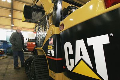 A visitor looks over a multiterrain loader made by Caterpillar at a farm show in Barre, Vt. Caterpillar Inc. was among companies that announced job cuts Thursday.  (FILE Associated Press / The Spokesman-Review)