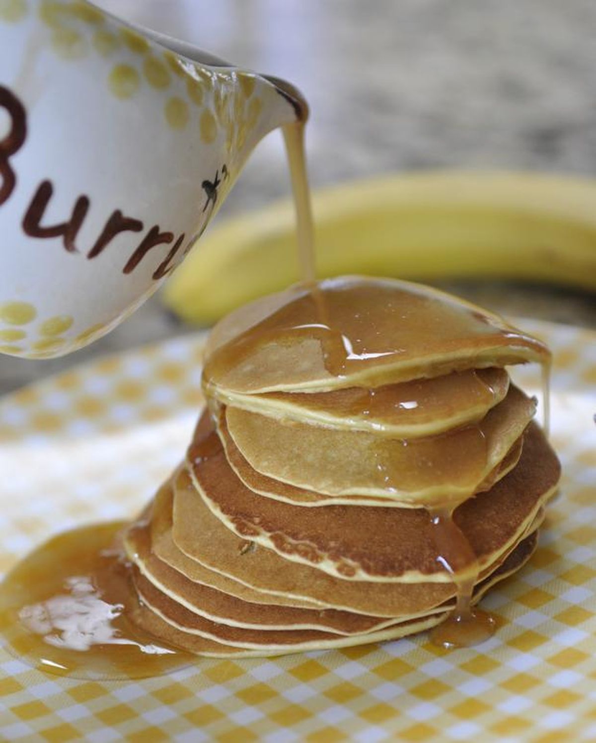 Shelly Kuney pours “burrup,” a mix of melted butter and warmed syrup, onto a stack of super-thin banana pancakes. The Spokane grandmother made these pancakes for her four children and now prepares them for her 10 grandchildren whenever they spend the night. (Adriana Janovich / SR)