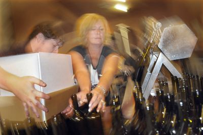 Melody Padrta tries to keep up with the bottling line Friday at Grande Ronde Winery.  (CHRISTOPHER ANDERSON / The Spokesman-Review)